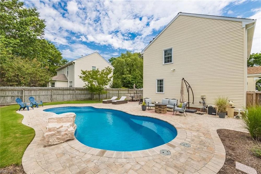 freeform fiberglass pool in mid-size suburban backyard