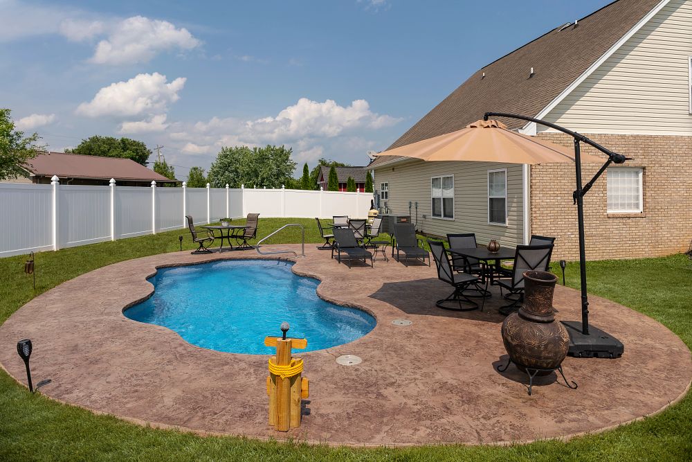 freeform fiberglass pool in small suburban backyard