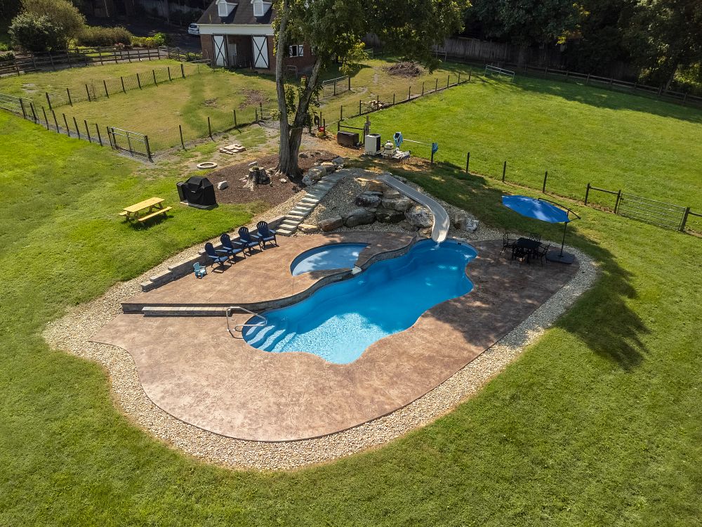 fiberglass pool with tanning ledge and long pool slide