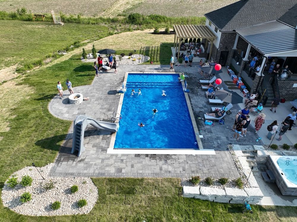 backyard party near vinyl liner pool with water slide