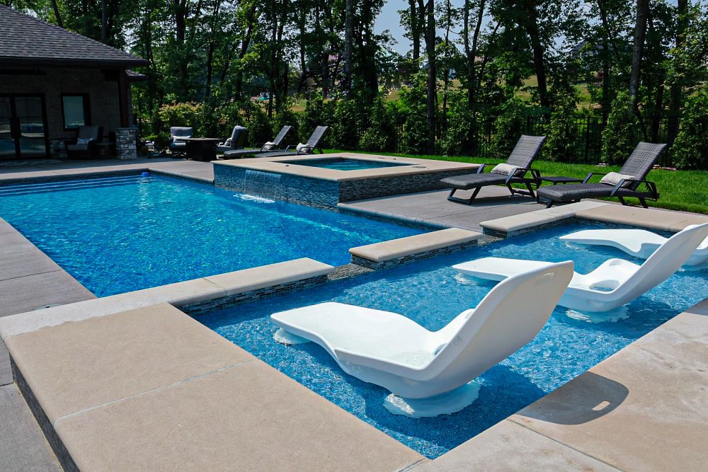 fiberglass pool with add-ons like a tanning ledge and spa with custom water features